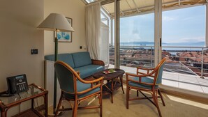 A balcony with wicker furniture, a sofa, and a table with fruit.