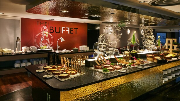 A buffet counter with various food items and a decorative wall with the text "THE BUFFET". - M Hotel Singapore City Centre (Singapore)