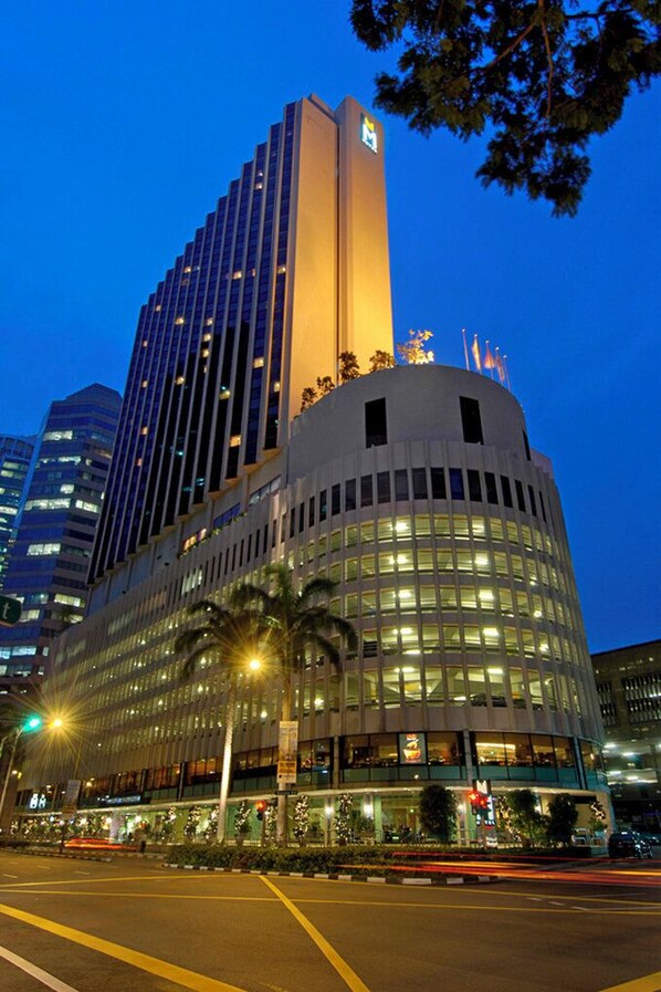 Un hotel moderno con una imponente torre vertical y una sección cilíndrica con grandes ventanales.