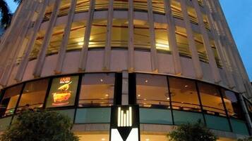 A hotel with a modern design, featuring a prominent 'M' sign and a large glass facade.