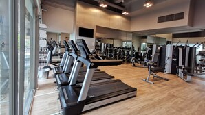 A modern gym with treadmills, weight machines, and a large mirror. - M Hotel Singapore City Centre (Singapore)