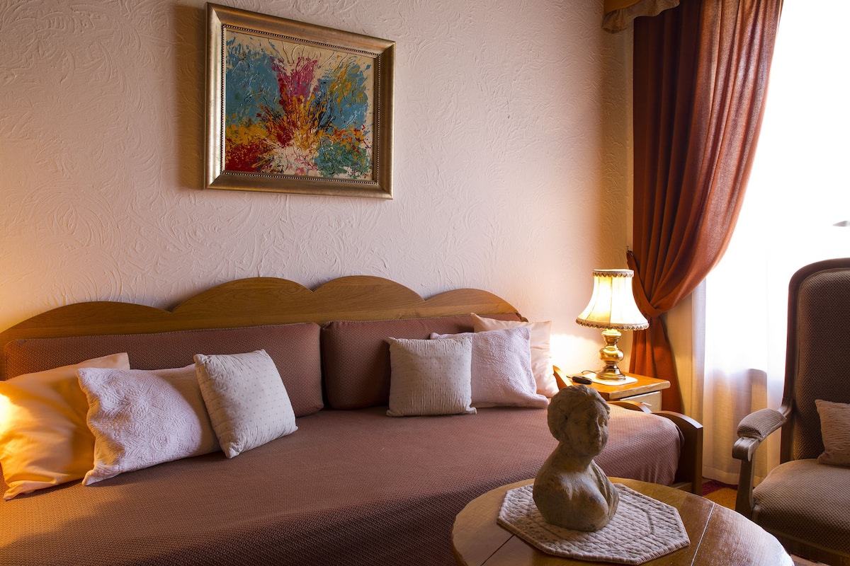 Une chambre d’hôtel avec un lit, une lampe, une chaise et un tableau au mur.