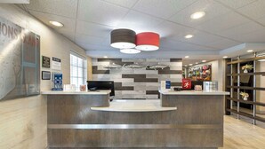 A reception area with a wooden reception desk, a map on the wall, and a fish-themed wall decoration. - Best Western Plus St. Simons (St. Simons Island)