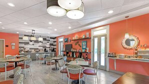 A restaurant with a modern interior, featuring a mix of seating arrangements and a variety of decor elements. - Best Western Plus St. Simons (St. Simons Island)