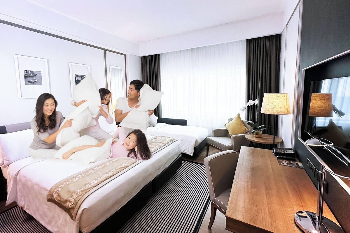 Une chambre d’hôtel avec un lit, un bureau, une télévision et une fenêtre avec des rideaux.