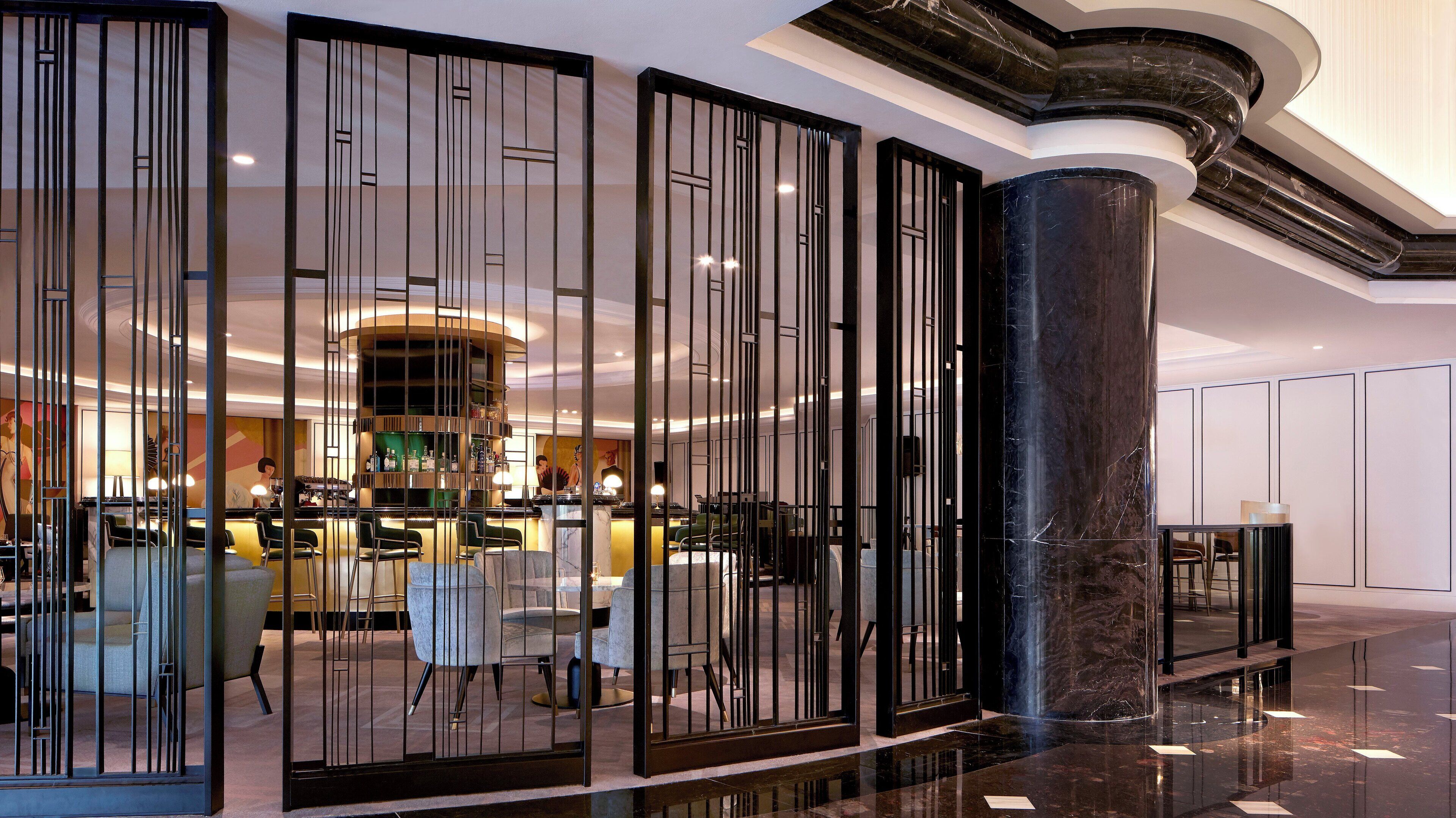 Eine moderne Hotelhalle mit Bar, Sitzgelegenheiten und einer Zierensäule.