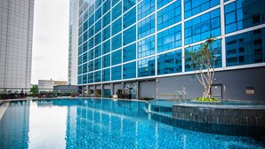 Un hôtel moderne doté d’une grande piscine intérieure, d’un jardin bien entretenu et d’une façade au style contemporain.