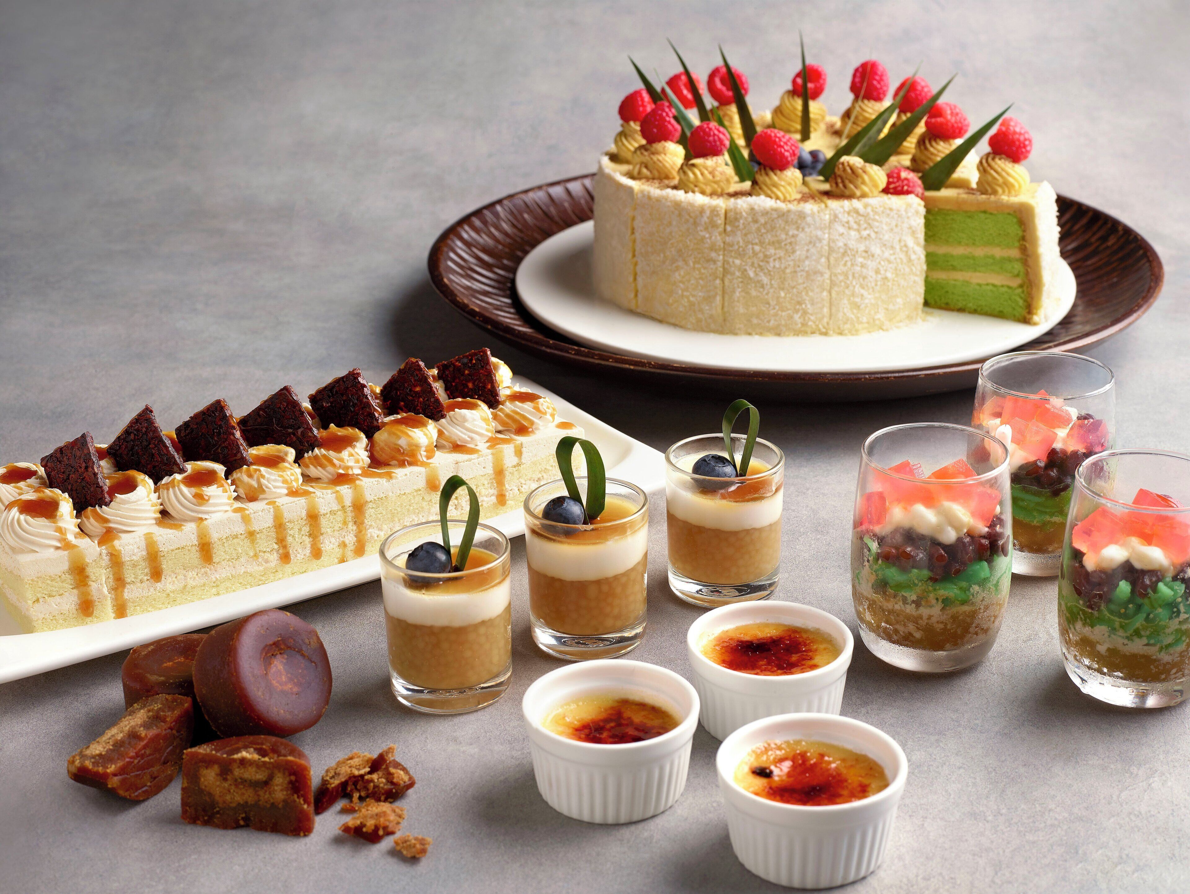 Une table de desserts avec divers gâteaux, pâtisseries et petits desserts servis dans des verrines.