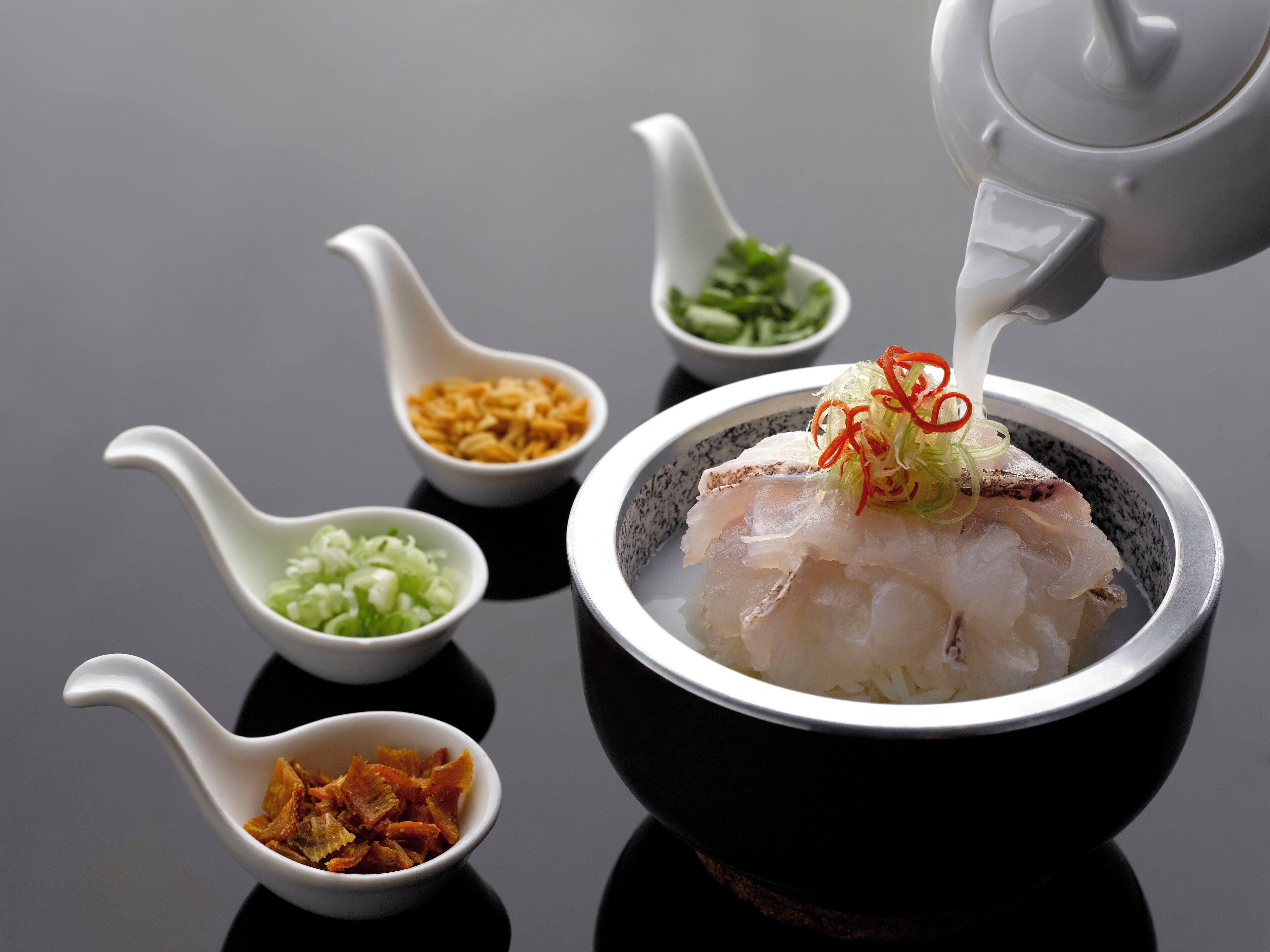 A bowl of sashimi with various garnishes and condiments.
