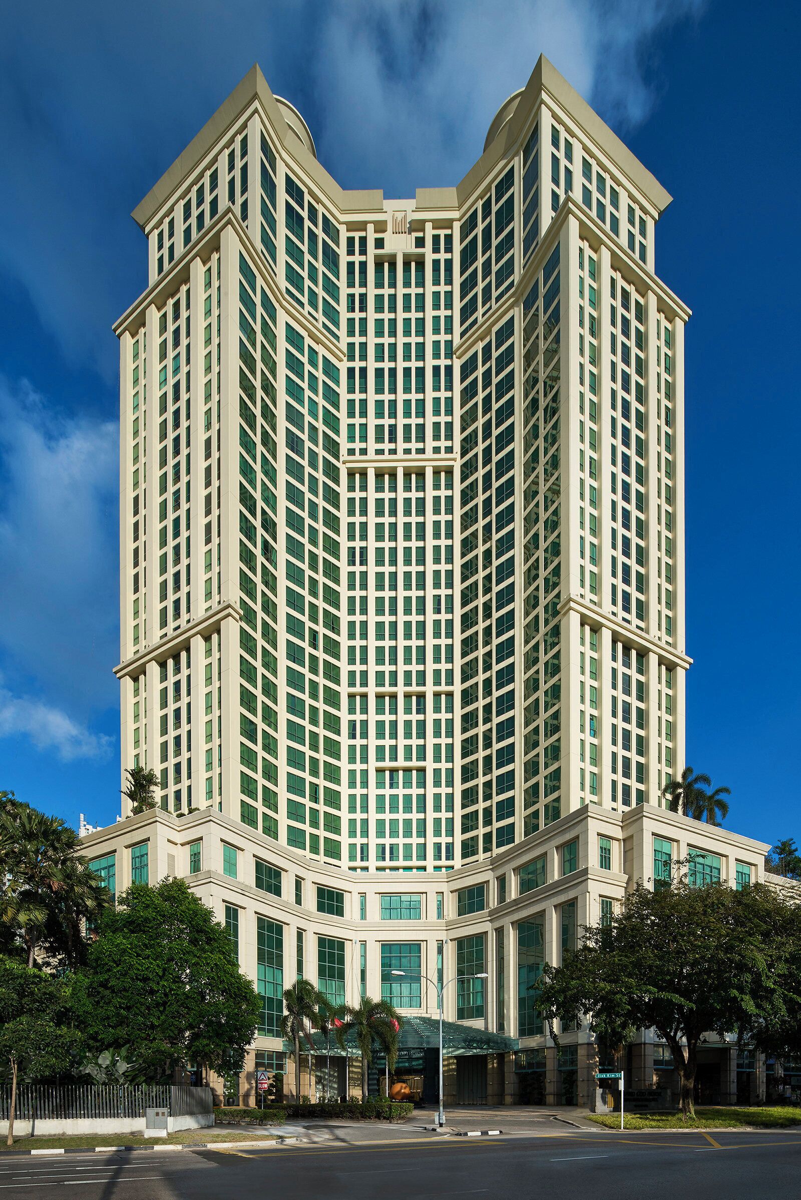 A tall, modern hotel with a symmetrical facade and large windows.