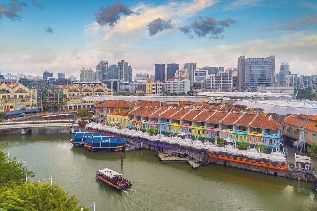 A waterfront area with colorful buildings, a bridge, and a boat dock.
