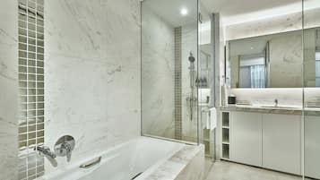 A modern bathroom with a glass-enclosed shower, a freestanding bathtub, and a vanity with a mirror.