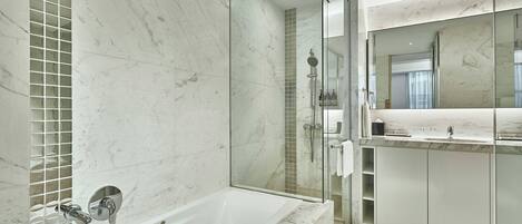 Un baño moderno con ducha de vidrio, una bañera independiente y un tocador con espejo.