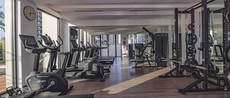 A gym with treadmills, ellipticals, and weightlifting equipment.