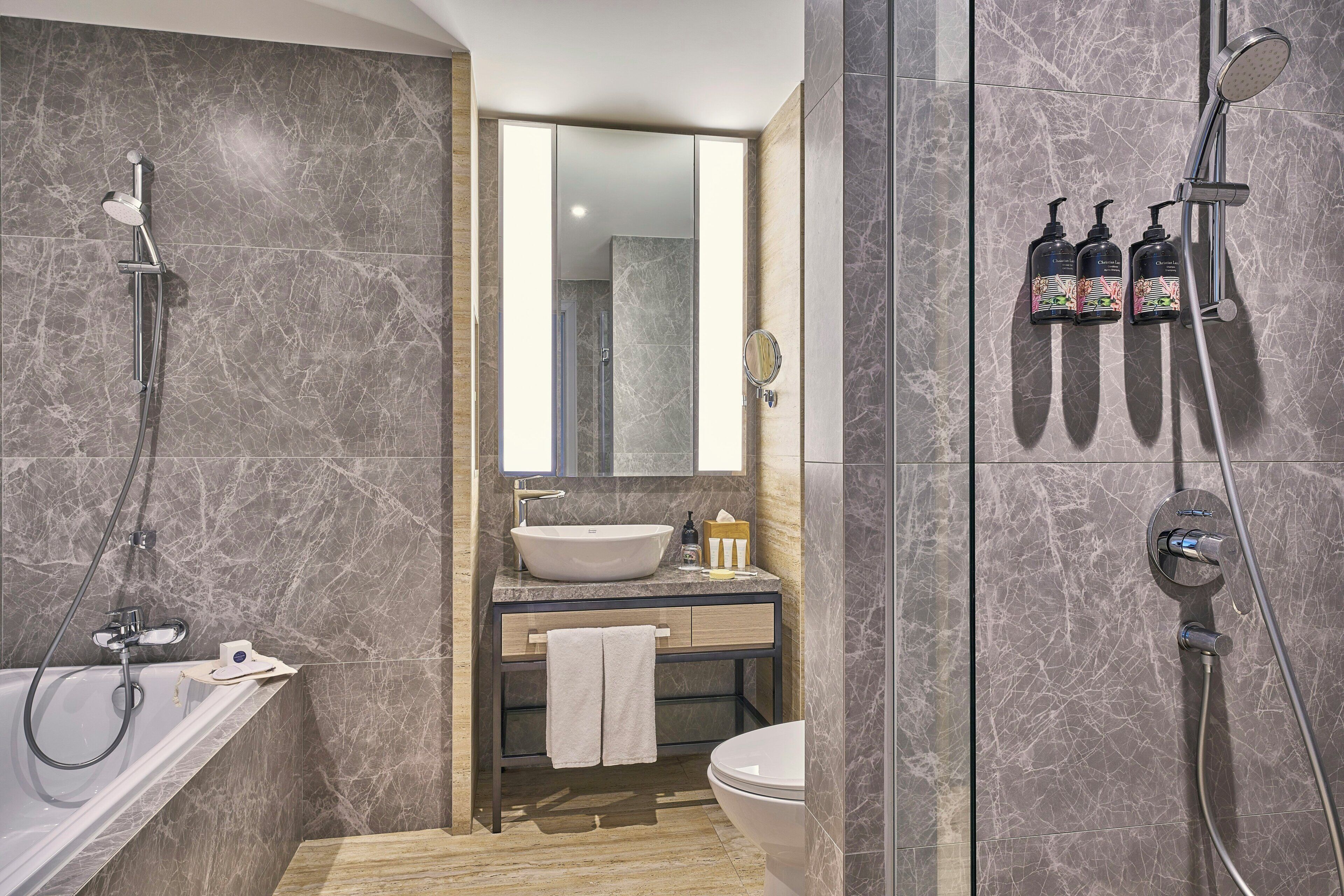 A modern bathroom with a bathtub, a sink, a toilet, and a shower.