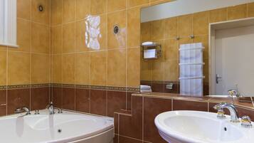 A bathroom with two sinks, a large mirror, and a towel rack.