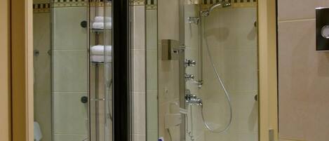 Un baño con lavamanos, espejo y ducha.