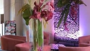 A room with a checkered floor, a glass vase with pink flowers, and pink chairs. - Belle Hôtel, Lille Ouest (Bailleul)