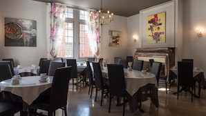 A dining area with multiple round tables, black chairs, and a chandelier. - Belle Hôtel, Lille Ouest (Bailleul)