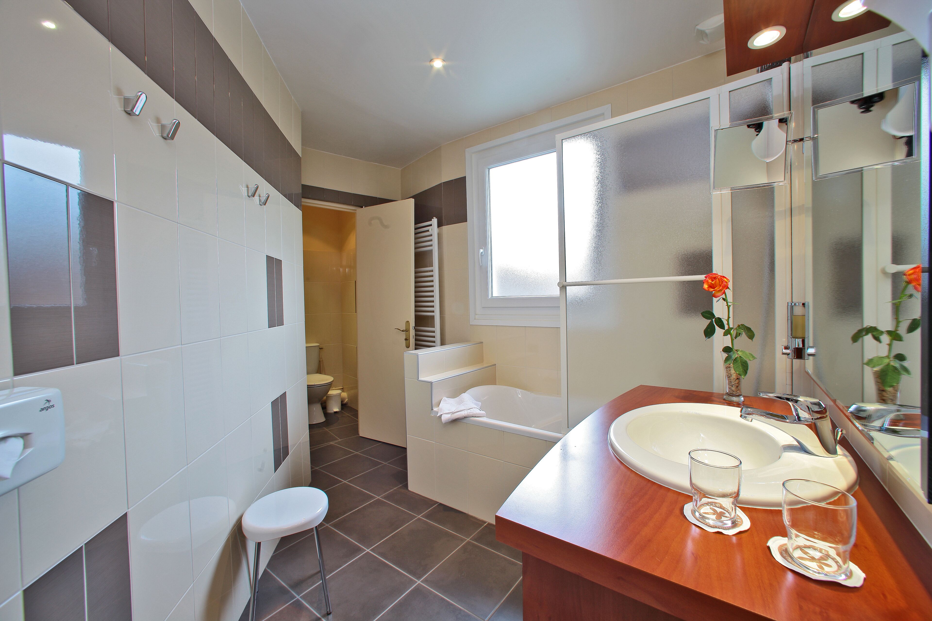 Een moderne badkamer met een grote wastafel, spiegel en toilet.