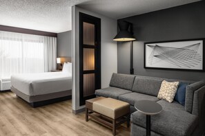 Une chambre d’hôtel moderne avec un lit, un canapé et une petite table.