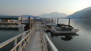 A marina with boats docked, a covered walkway, and mountains in the background. - Harrison Hot Springs Resort and Spa (Harrison Hot Springs)