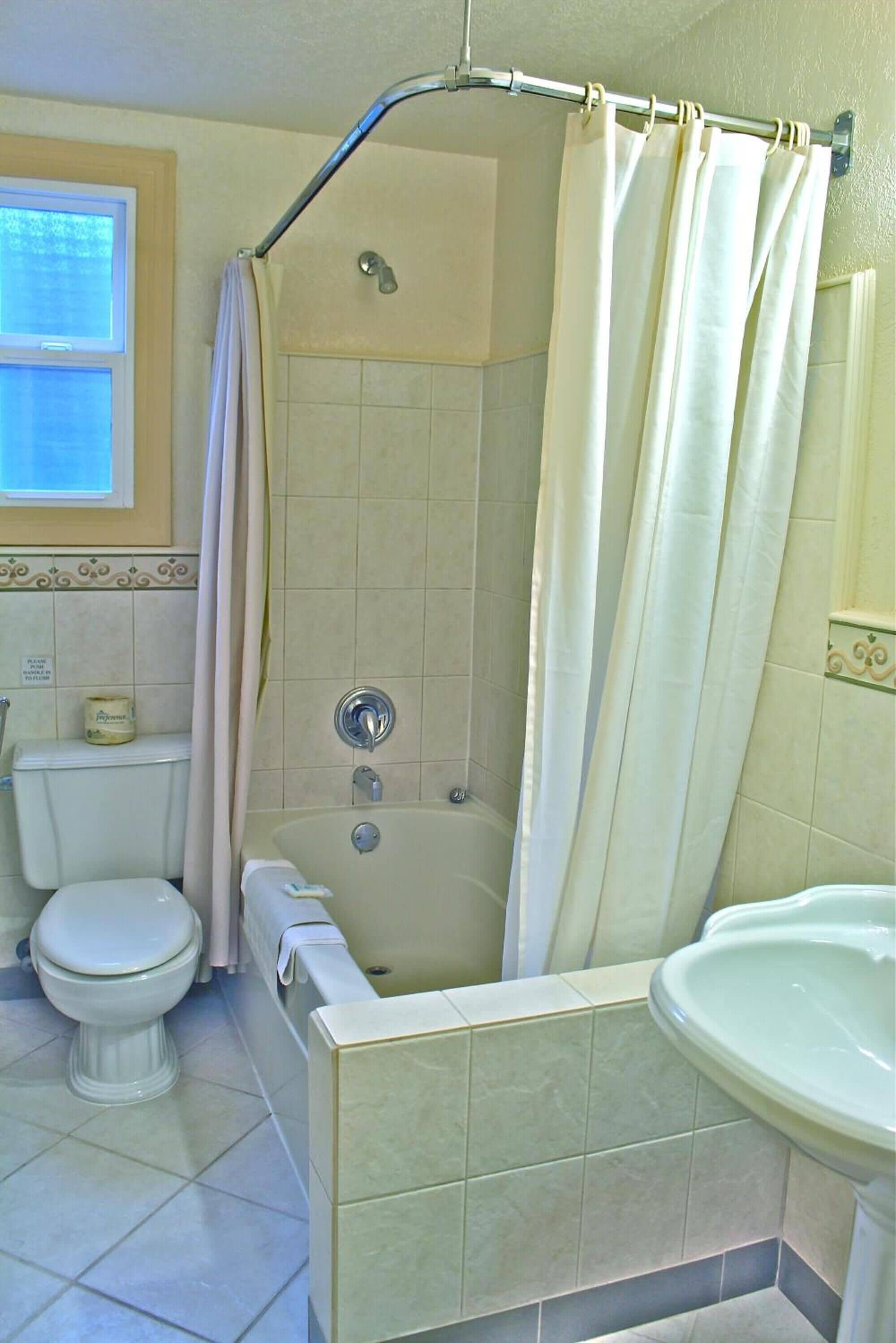 A bathroom with a bathtub, toilet, and sink.