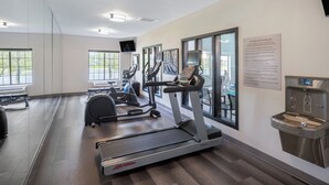 A modern fitness room with treadmills, elliptical machines, and a water fountain. - Staybridge Suites West Des Moines by IHG (West Des Moines)