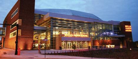 A modern Wells Fargo Arena with a glass facade and a prominent sign.