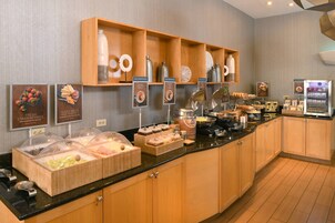 Una mesa de buffet con diversos alimentos y aderezos.