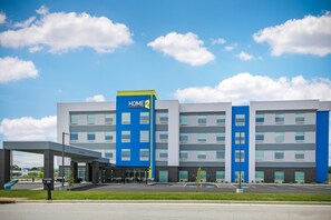 A multi-story hotel with a blue and white facade, a covered entrance, and a parking lot. - Home2 Suites by Hilton Somerset (Somerset)