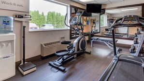 A gym with cardio equipment, a water dispenser, and a large window with a view of trees and parked cars. - Comfort Suites Elkhart North (Elkhart)