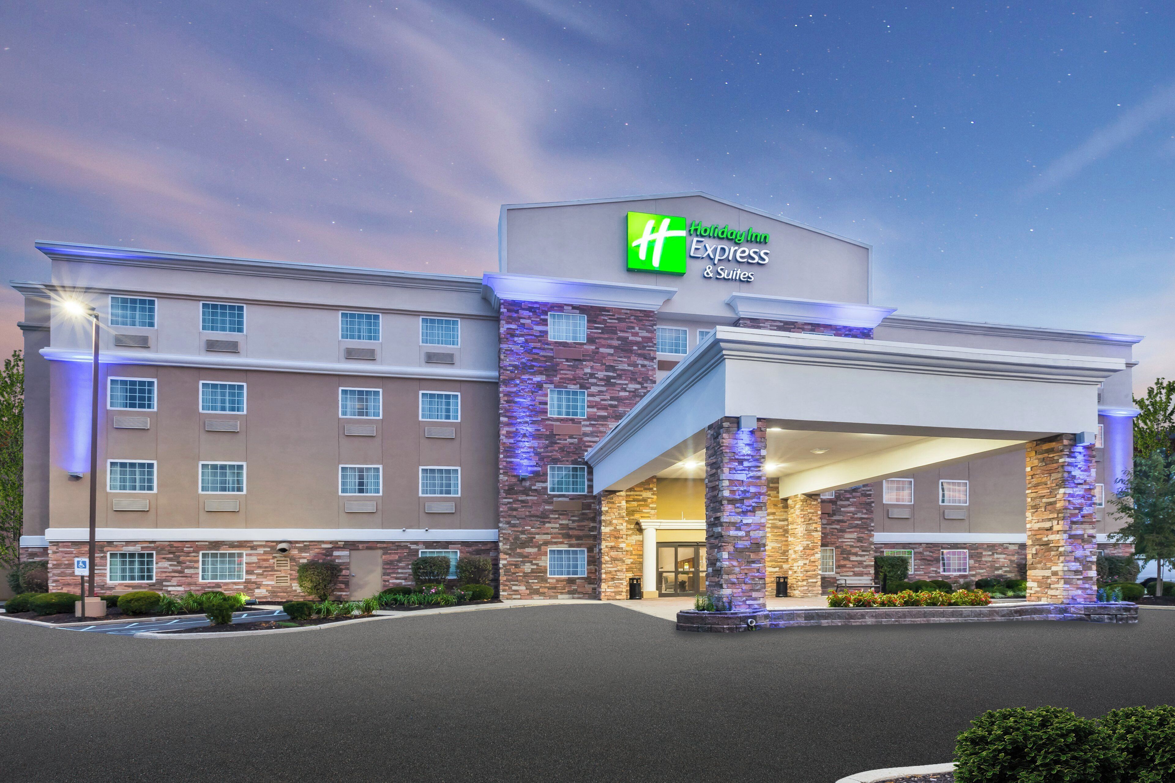 A Holiday Inn Express & Suites hotel with a brick facade and a covered entrance.