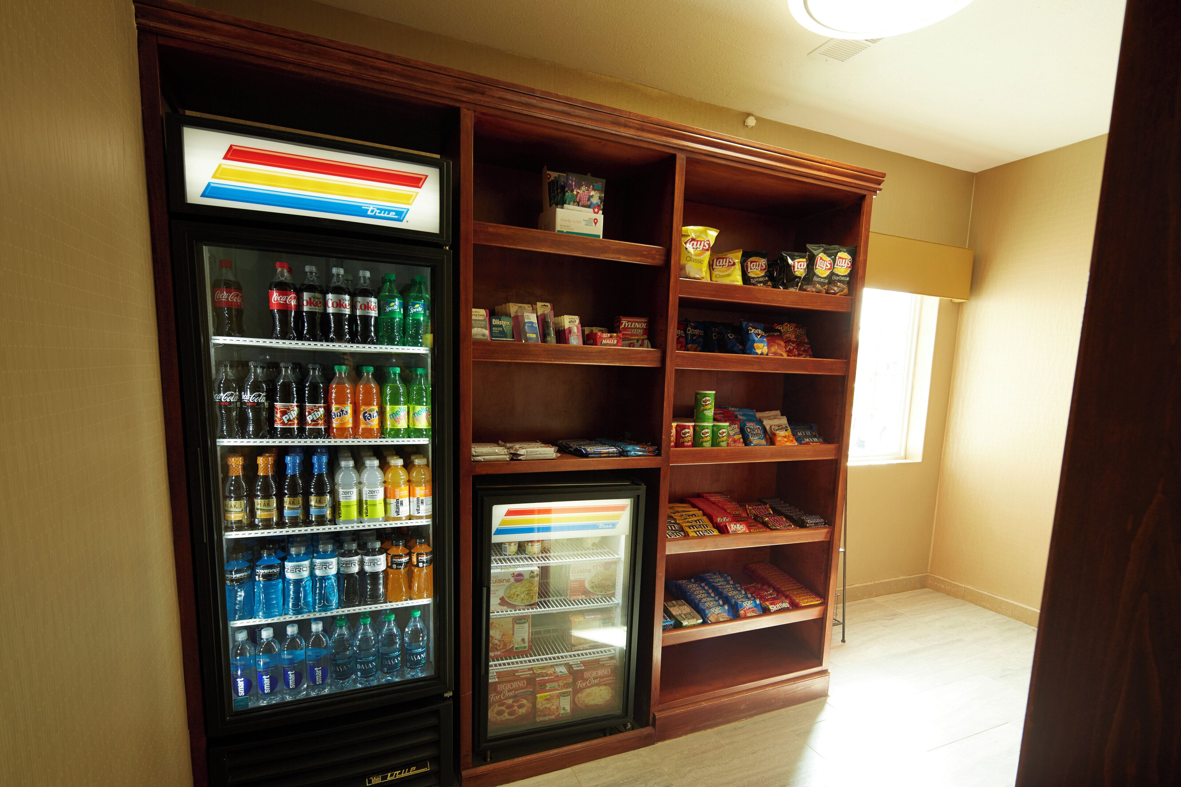 A vending machine with a variety of beverages and snacks, and a refrigerated display case with frozen items.
