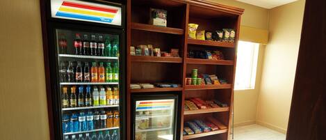 A vending machine with a variety of beverages and snacks, and a refrigerated display case with frozen items.