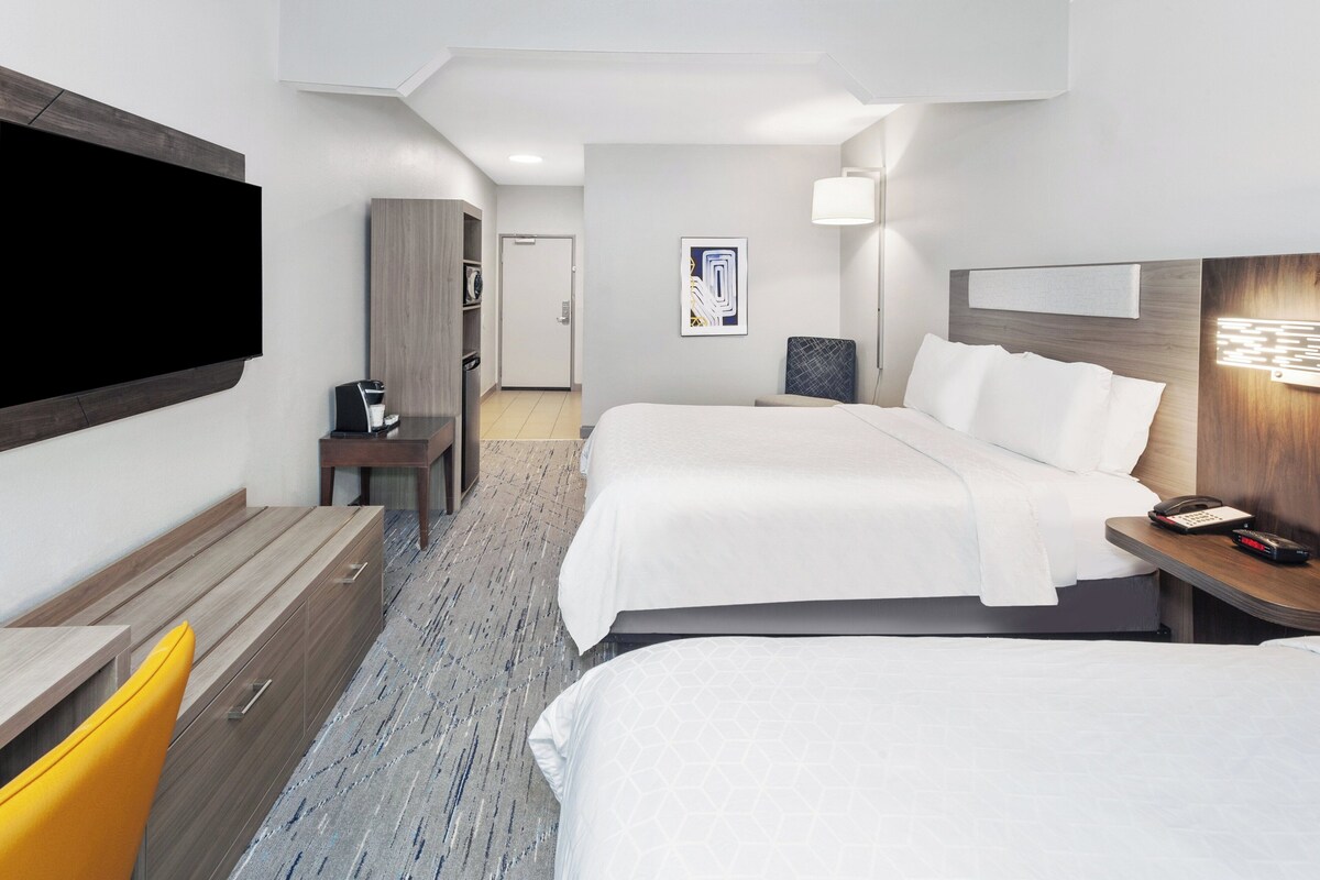 Une chambre d’hôtel avec deux lits, un bureau, une télévision et une salle de bain.