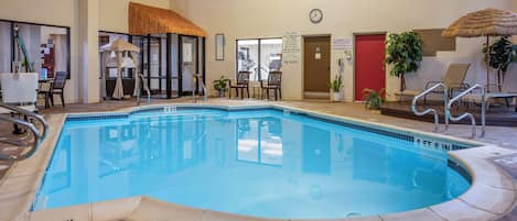 Una piscina techada, sillones reclinables de piscina