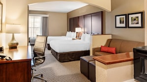 A hotel room with a desk, two beds, a sofa, and a fireplace. - Comfort Suites State College near Penn State (State College)