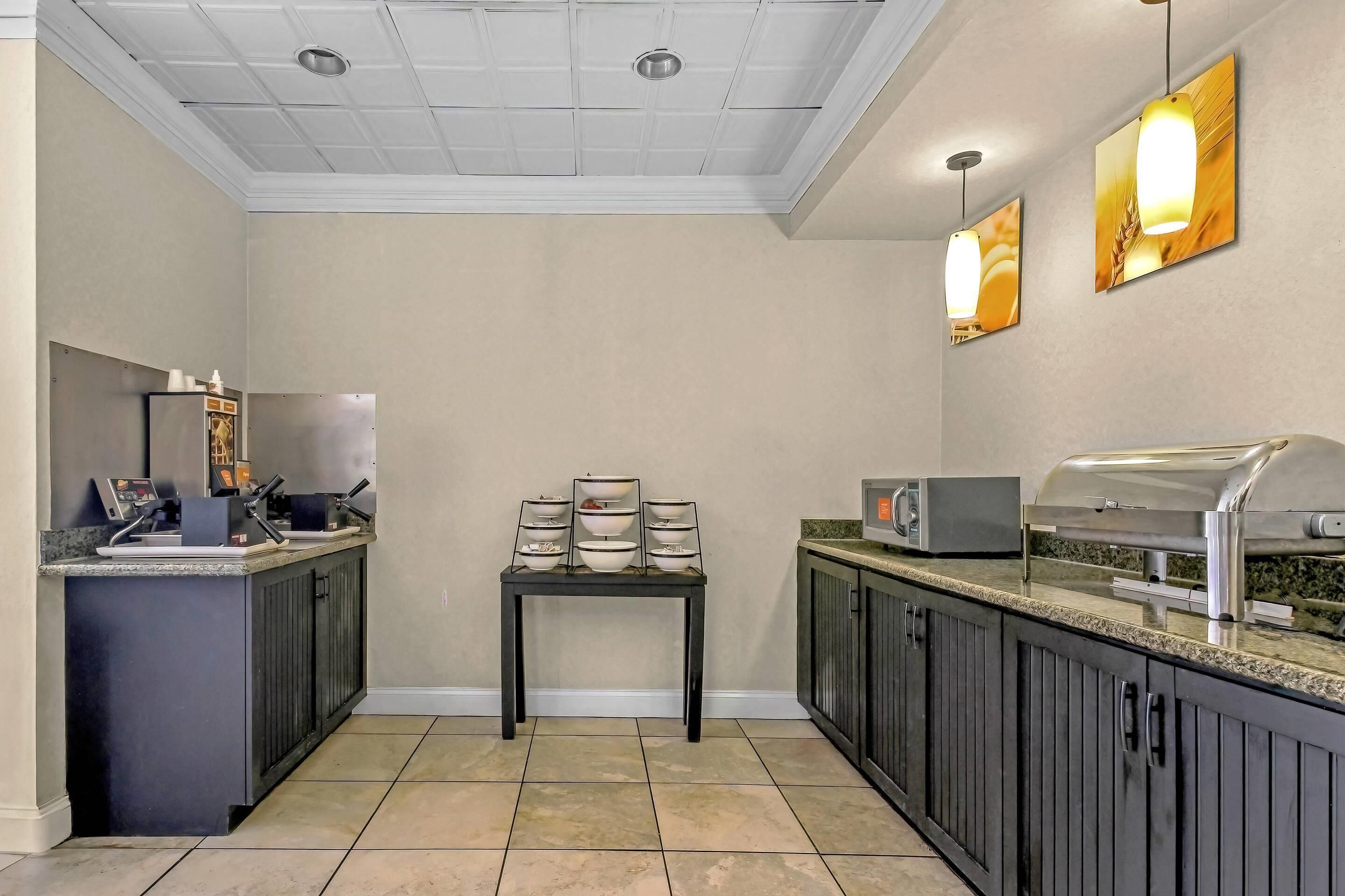 A modern kitchen with a built-in refrigerator, microwave, and grill station.