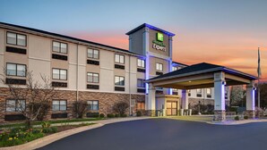 A Holiday Inn Express hotel with a stone facade, multiple windows, and a covered entrance. - Holiday Inn Express Marshall by IHG (Marshall)