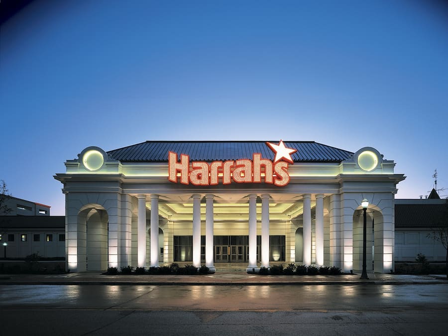 Fasaden på ett Harrah's-hotell med en framträdande, upplyst skylt, stora pelare och en stjärnsymbol.