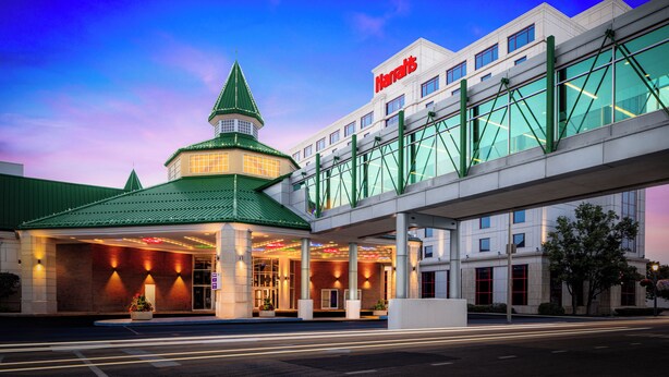 A hotel with a green-roofed building, a covered entrance, and a glass-walled extension.
