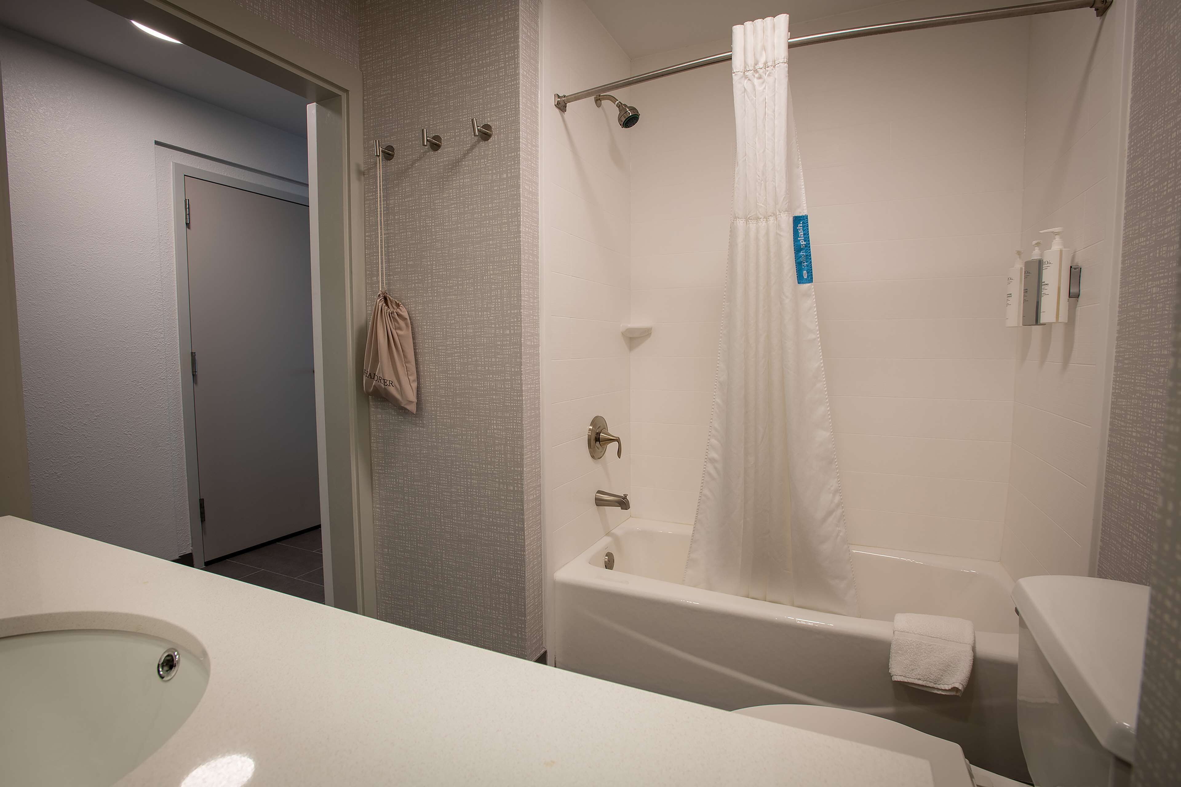 A bathroom with a bathtub, toilet, and sink.