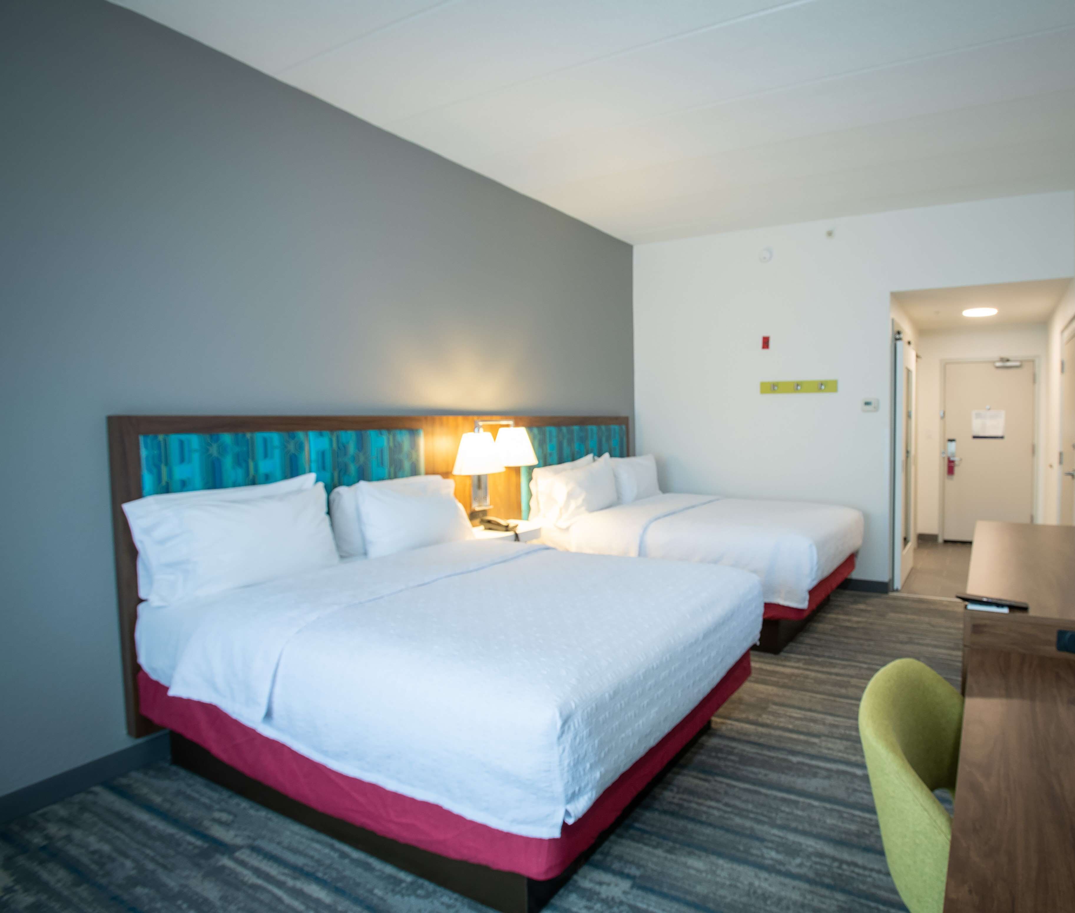 Une chambre d’hôtel avec deux lits, un bureau et une chaise.