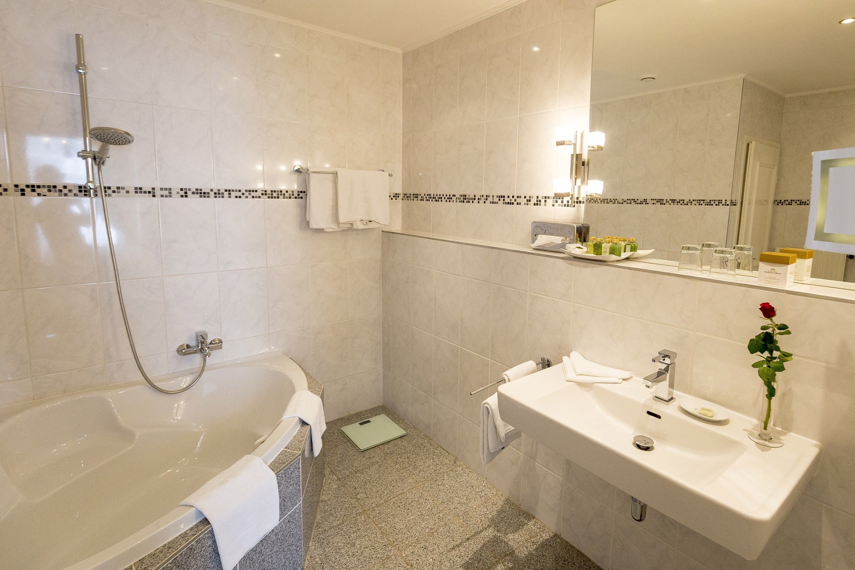 A modern bathroom with a bathtub, a sink, and a mirror.