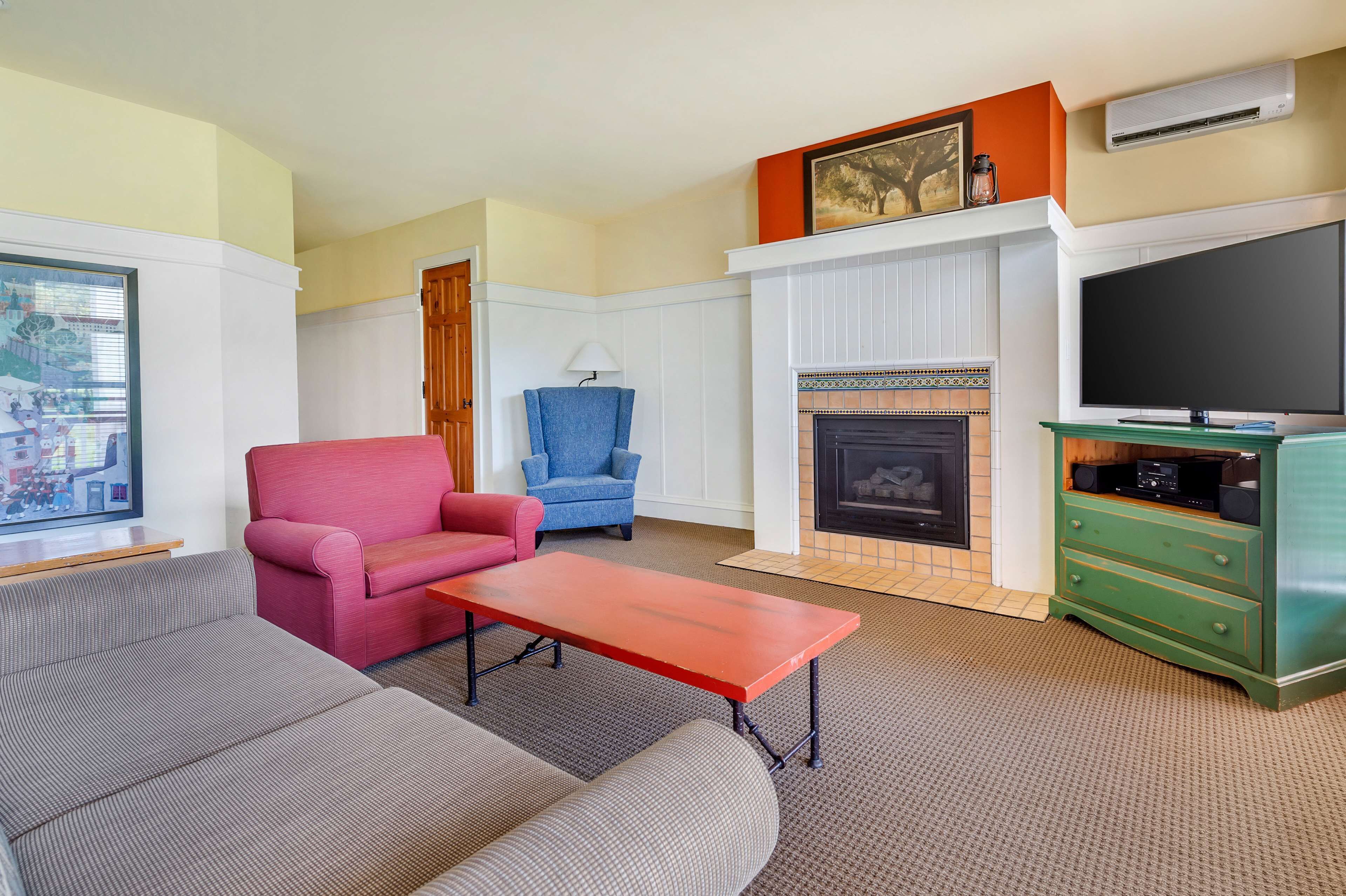 A living room with a fireplace, a television, and a green cabinet.