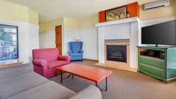 A living room with a fireplace, a television, and a green cabinet.