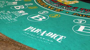 A close-up of a casino table with the word "PARADISE" and "HOTEL CASINO" visible.