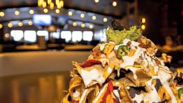 Un plato de nachos con diferentes ingredientes y una porción de guacamole encima.