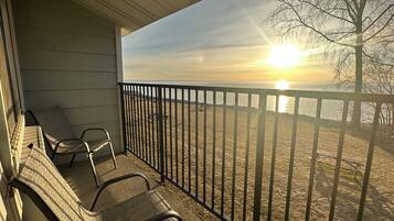 Enjoy breathtaking views of the water from this balcony with a table and two chairs.